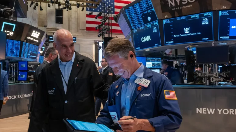 Wall Street stock traders looking at screens and smiling