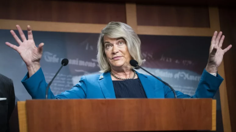 U.S. Senator Cynthia Lummis standing behind a microphone podium.